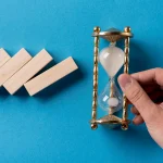 top-view-domino-pieces-with-businessman-holding-hourglass